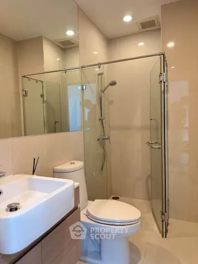 Modern bathroom with glass shower enclosure and sleek fixtures