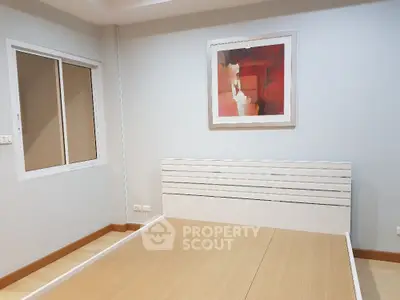 Spacious bedroom with modern decor and large window for natural light