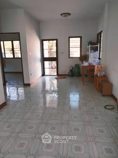Spacious living area with tiled flooring and natural light, ideal for cozy family gatherings.