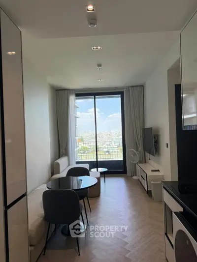 Modern living room with city view, featuring sleek furniture and large windows for natural light.