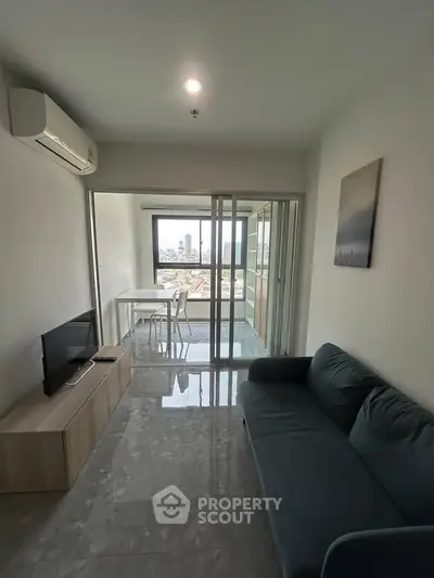 Modern living room with city view, featuring sleek furniture and large windows for natural light.