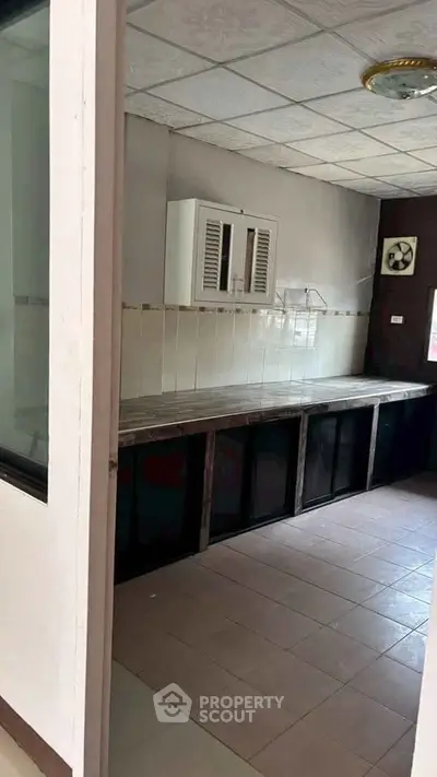 Spacious kitchen with tiled floor and ample counter space in modern home.