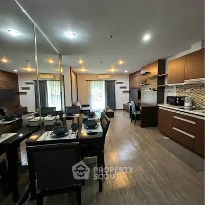 Spacious modern living room with dining area and stylish kitchen in open layout apartment.