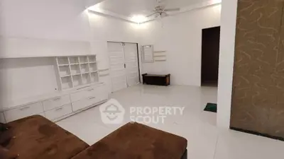Spacious living room with modern white cabinetry and ceiling fan
