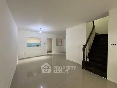 Spacious modern living room with staircase and tiled flooring