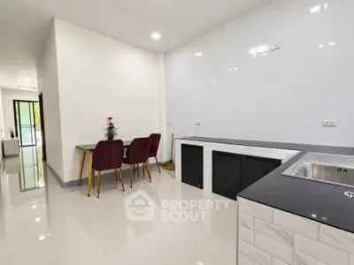 Modern kitchen with sleek countertops and dining area in open layout apartment