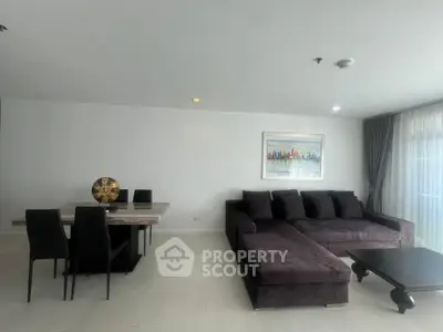 Spacious modern living room with plush sectional sofa and elegant dining area, perfect for entertaining.