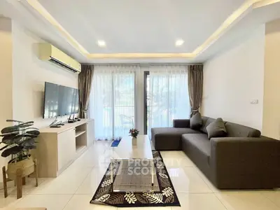 Modern living room with sleek furniture and large windows offering natural light.