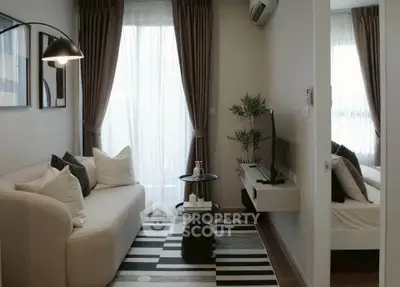 Cozy living room with modern decor and natural light, featuring a stylish sofa and TV setup.