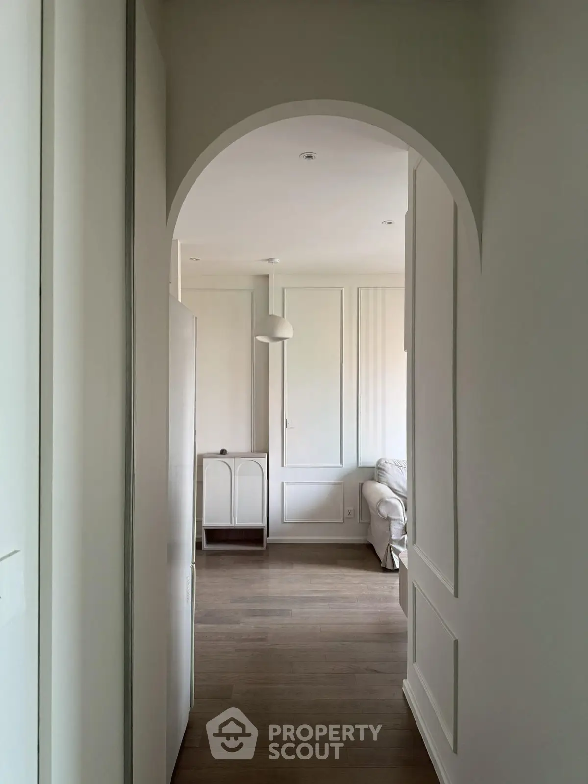Elegant hallway leading to a cozy living room with modern decor and soft lighting.