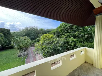 Spacious balcony with lush garden view, perfect for relaxation and outdoor enjoyment.