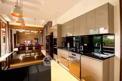 Luxurious modern kitchen with sleek cabinetry and open layout, featuring high-end appliances and elegant lighting.