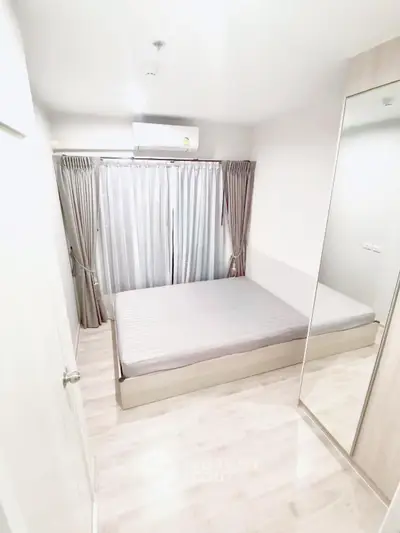 Modern minimalist bedroom with large window and mirrored wardrobe