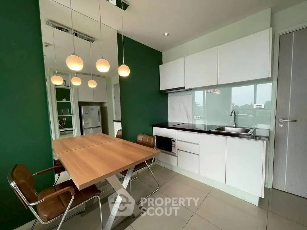 Modern kitchen with sleek design and stylish lighting in a contemporary apartment.