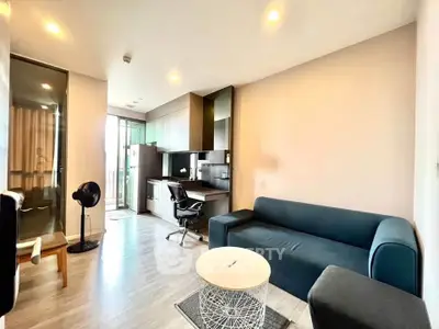 Modern living room with sleek furniture and open layout, featuring a cozy sofa and stylish decor.