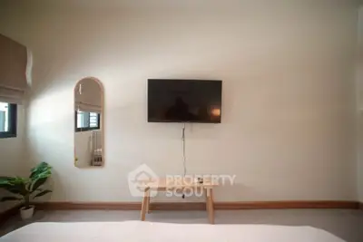 Modern bedroom with wall-mounted TV and stylish decor