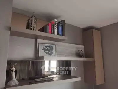 Modern living room with stylish shelving and decor, featuring books and art pieces.