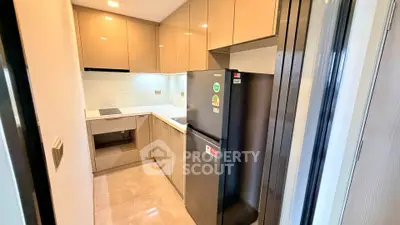 Modern kitchen with sleek cabinetry and stainless steel appliances in a compact layout.