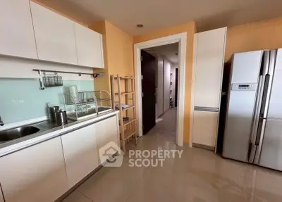 Modern kitchen with sleek cabinets and stainless steel fridge in a stylish apartment.