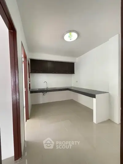 Spacious modern kitchen with sleek countertops and ample storage cabinets.