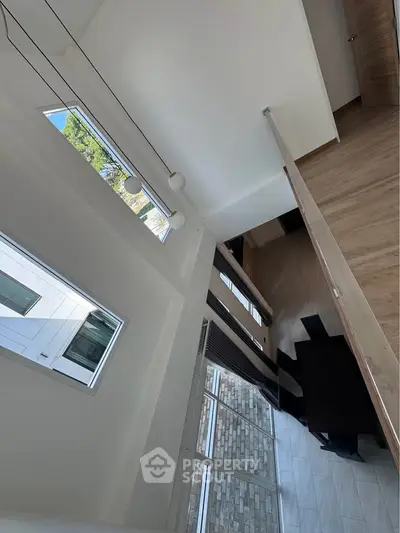Stunning modern living room with high ceilings and large windows offering abundant natural light.