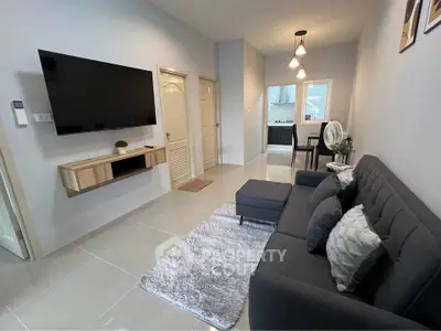 Modern living room with sleek furniture and wall-mounted TV in a stylish apartment.