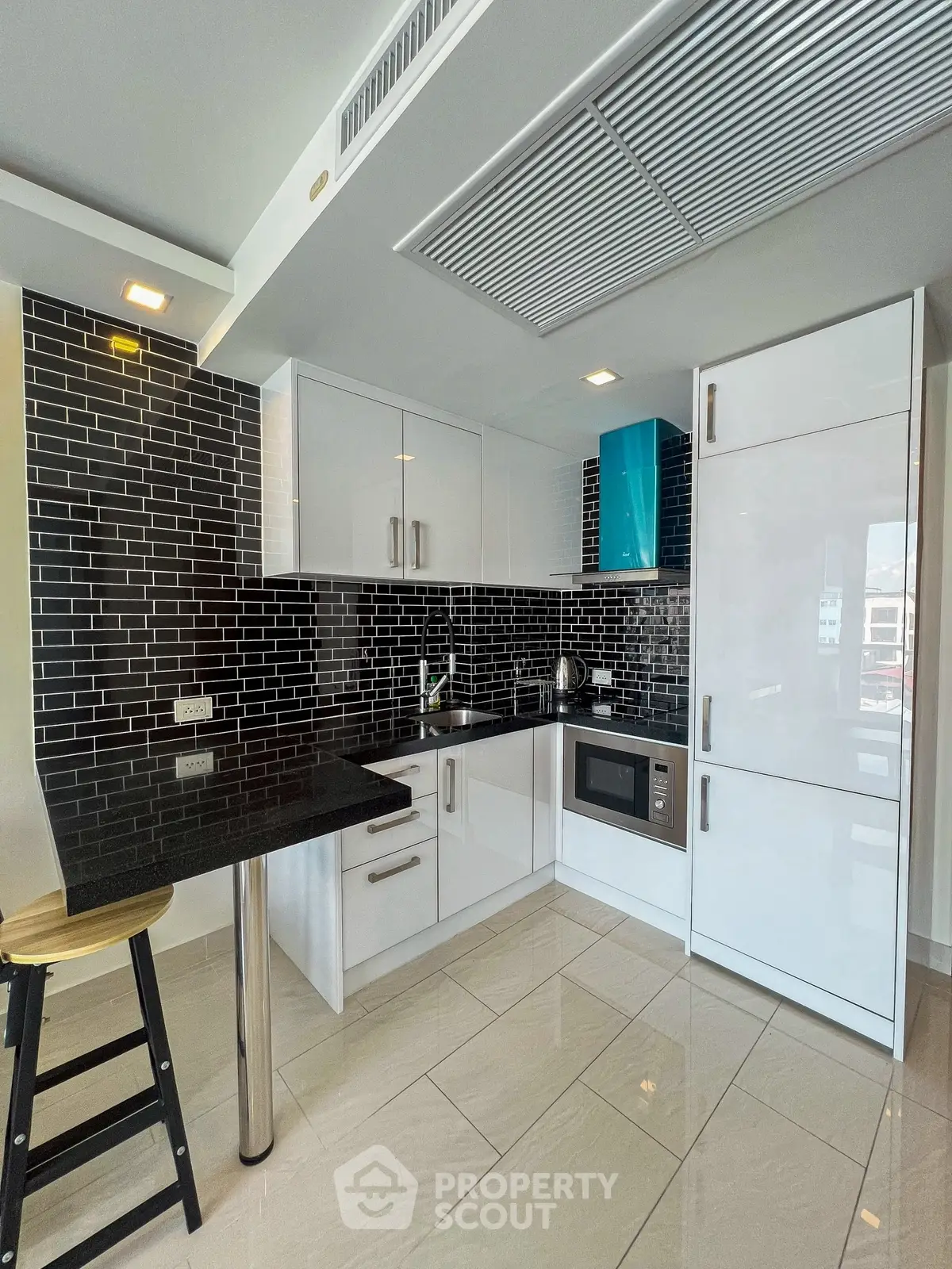 Modern kitchen with sleek black and white design, featuring built-in appliances and stylish backsplash.