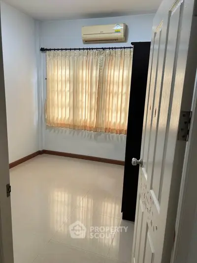 Bright empty room with air conditioning and large window, perfect for customization.