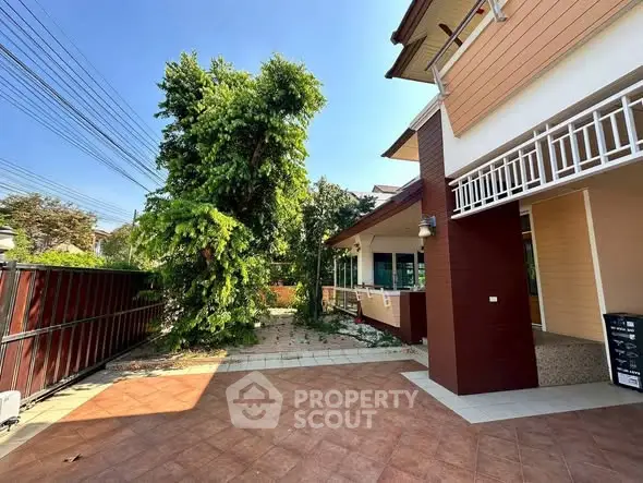 Charming house exterior with spacious patio and lush greenery, perfect for outdoor relaxation.