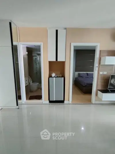 Modern apartment interior with open layout, featuring a bedroom and bathroom entrance, sleek design.
