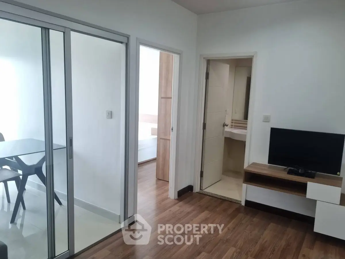 Modern apartment interior with sliding glass doors and wooden flooring
