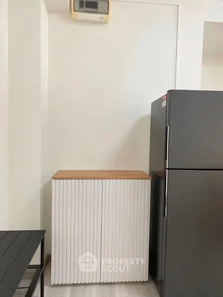 Modern kitchen corner with sleek fridge and stylish cabinet