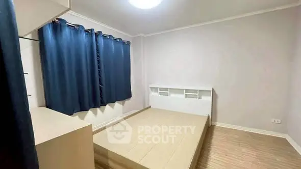 Spacious bedroom with modern design and ample natural light, featuring elegant wooden flooring and stylish curtains.