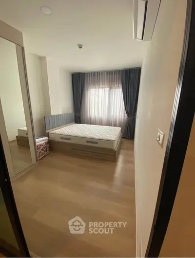Spacious bedroom with large window and modern furnishings, perfect for comfort and relaxation.