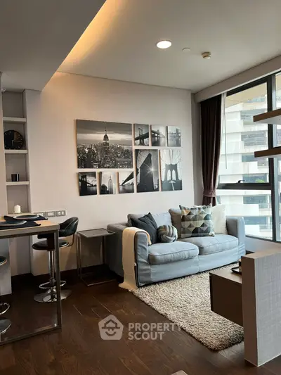 Modern living room with stylish decor and large windows offering natural light.