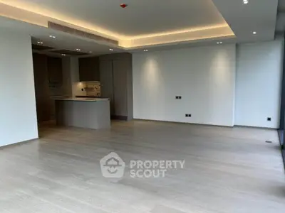 Spacious modern living room with open kitchen and elegant lighting