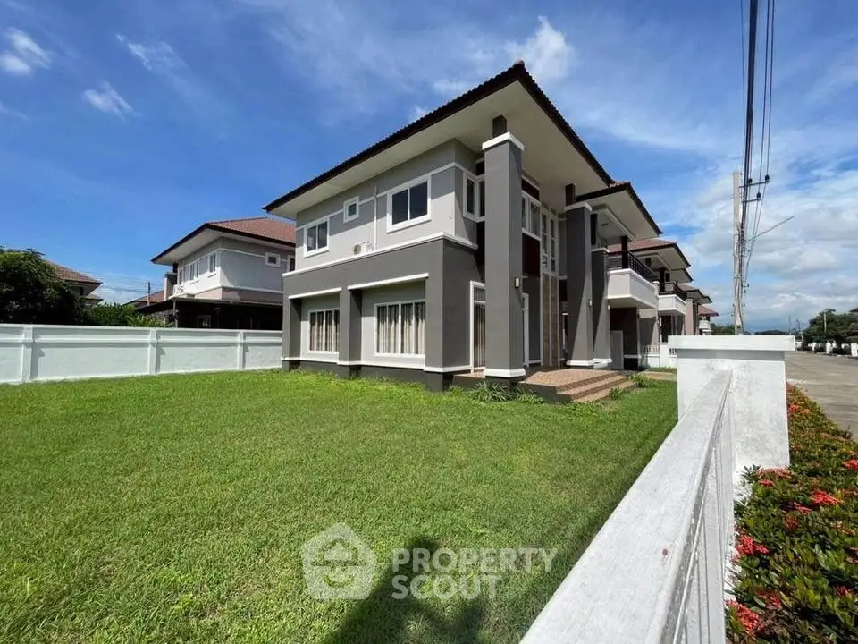 Modern two-story house with spacious lawn and contemporary design in a serene neighborhood.