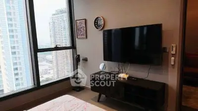 Modern bedroom with city view, featuring a sleek TV setup and stylish decor.