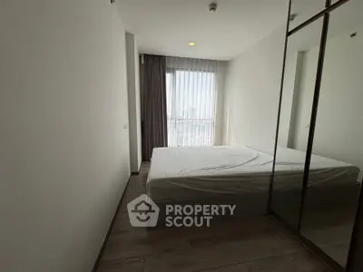 Modern minimalist bedroom with large window and mirrored closet