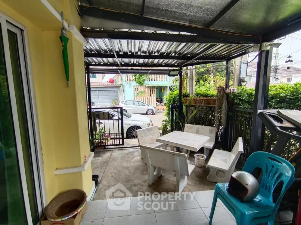 Charming covered patio with outdoor seating in a cozy residential area.