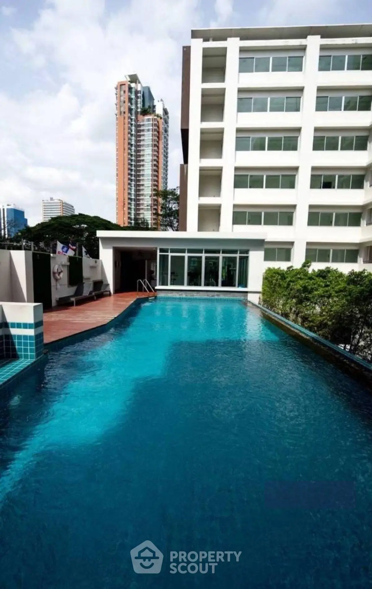 Luxurious apartment building with stunning rooftop pool and city view.