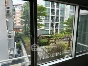Modern apartment view with lush greenery and nearby buildings