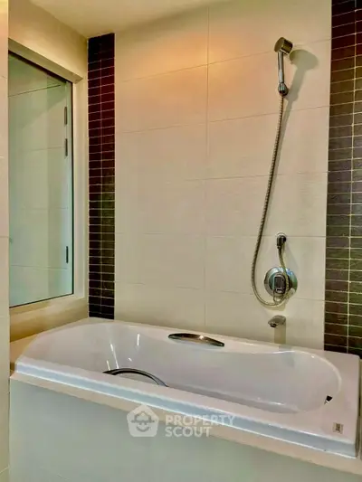 Modern bathroom with sleek bathtub and shower in contemporary design.