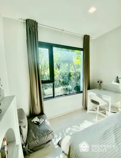 Bright bedroom with large window and study desk, ideal for natural light lovers.