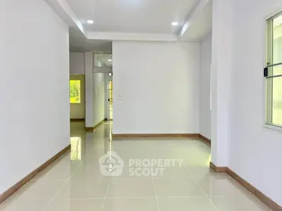 Spacious and bright interior with glossy tiled floors and modern recessed lighting.