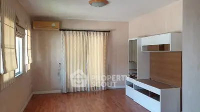 Spacious living room with wooden flooring and modern furniture, perfect for cozy gatherings.