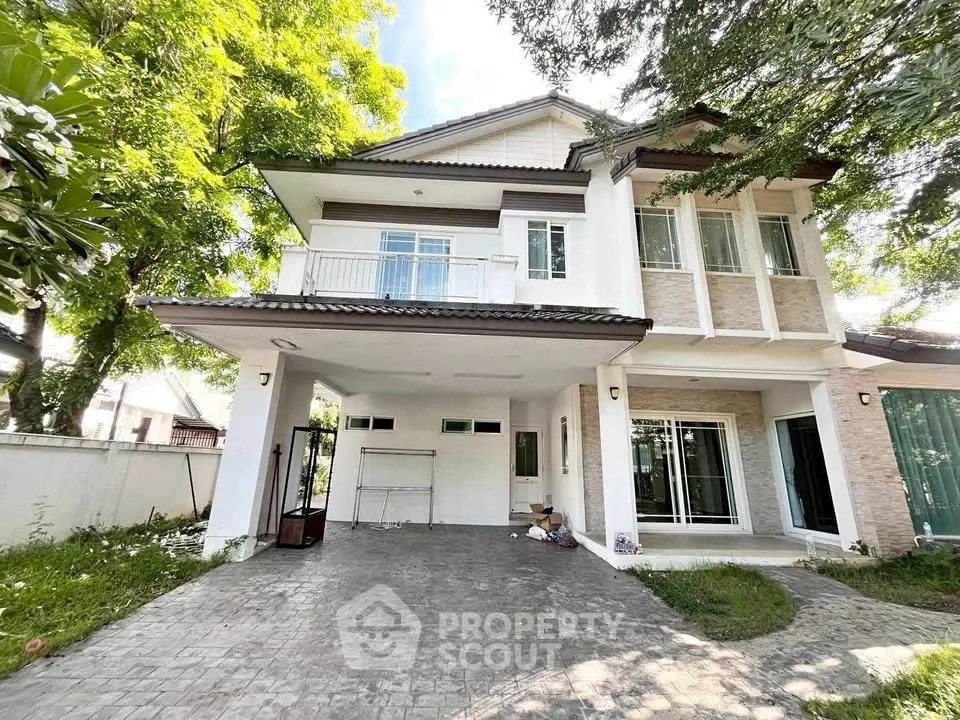 Charming two-story house with spacious driveway and lush greenery, perfect for family living.