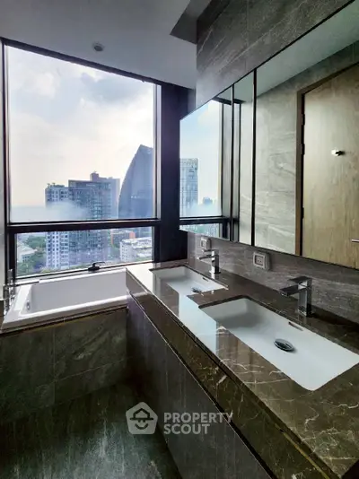 Luxurious bathroom with dual sinks and city view in high-rise apartment