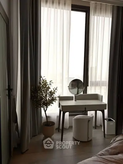 Elegant bedroom corner with vanity table and large window, perfect for natural light lovers.