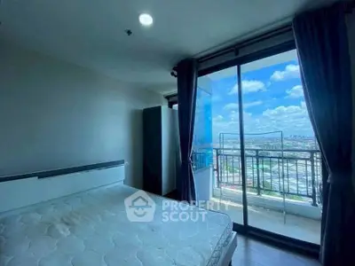 Spacious bedroom with balcony offering stunning city views and abundant natural light.